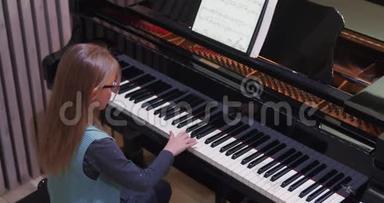 孩子在家学弹钢琴。 孩子练钢琴。 侧视。 小女孩弹钢琴